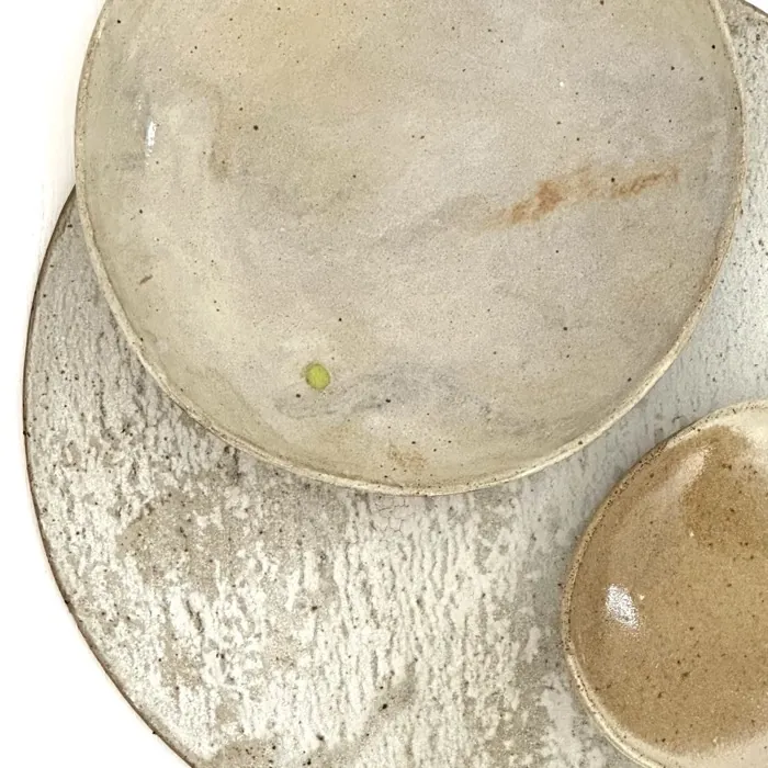 Two cream plates stacked on a wash of white