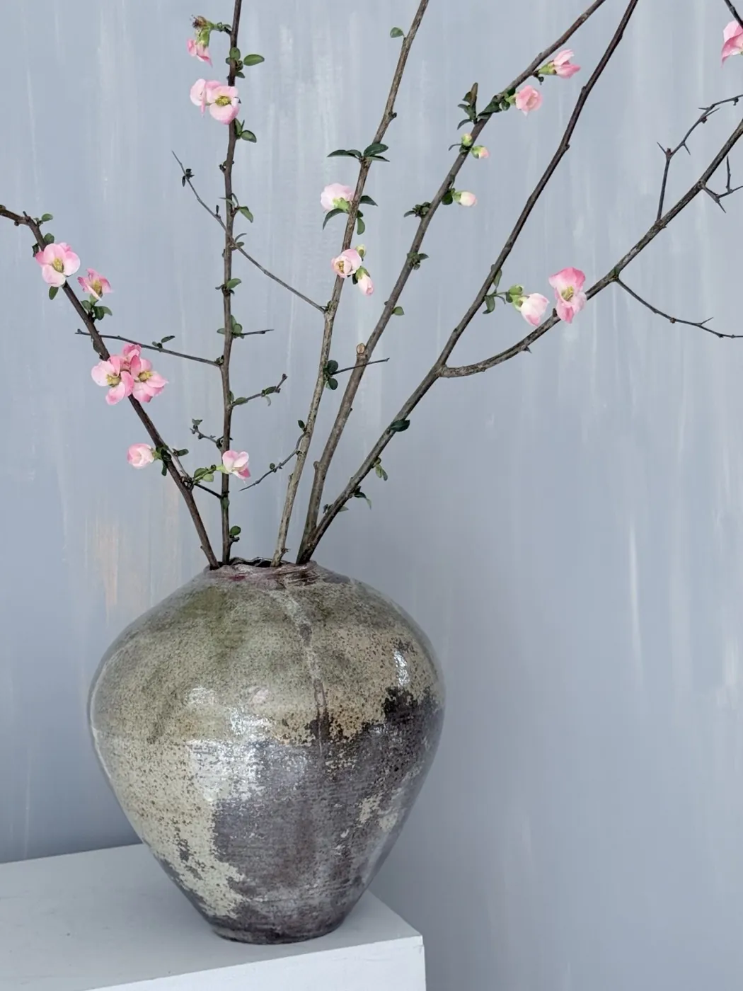 Cherry blossom branches in a stoneware vessel