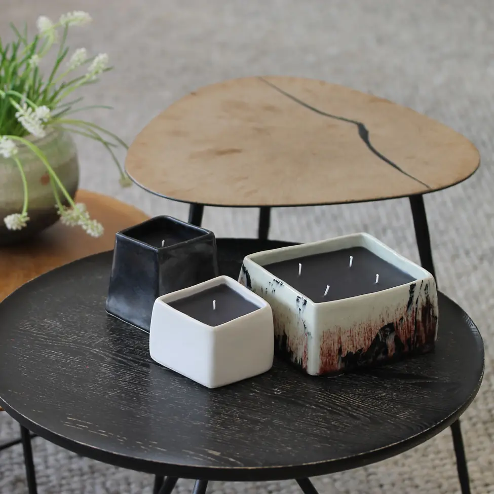 Three square candles styled on a black side table