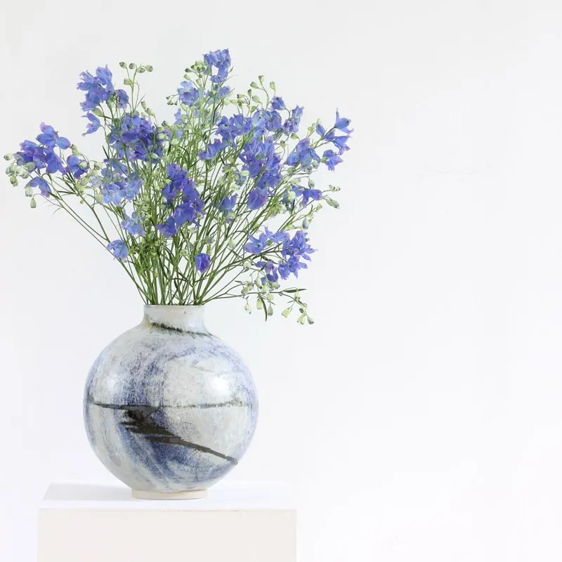 Blue delphiniums in a marbled vessel
